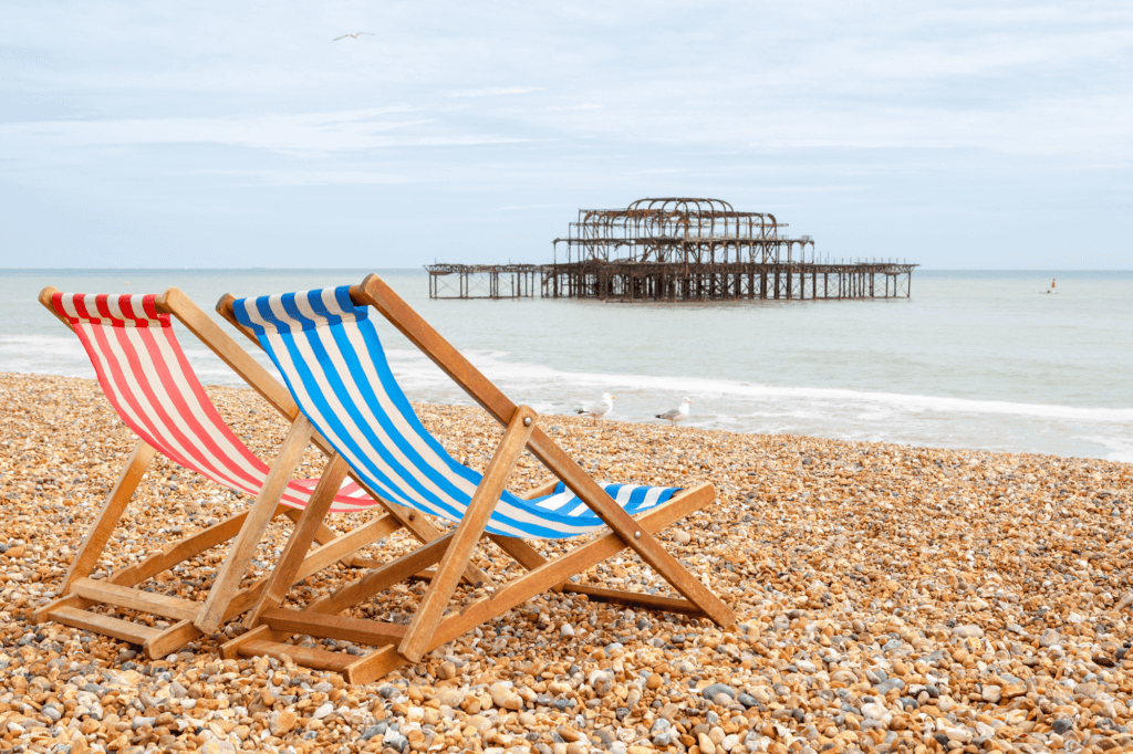 two striped beach chairs on the rocky beach of Brighton