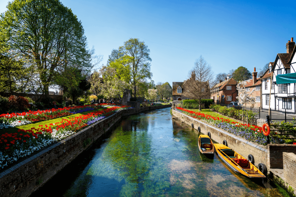 view of a canal in Canterbury with boats and flowers