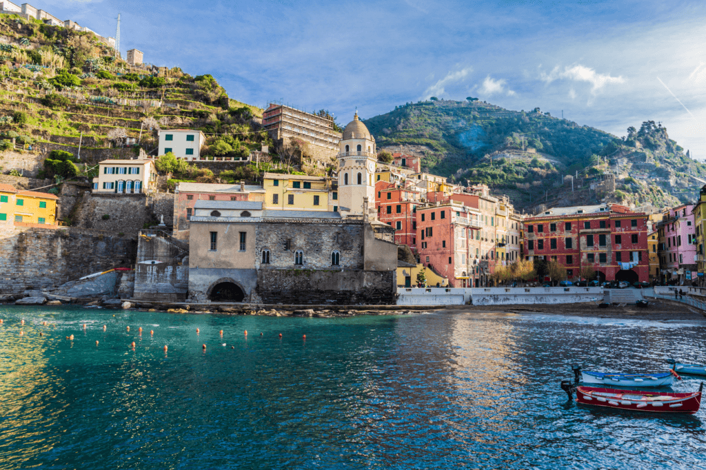 a view of the blue sea and the coastal town of Vernazza Italy