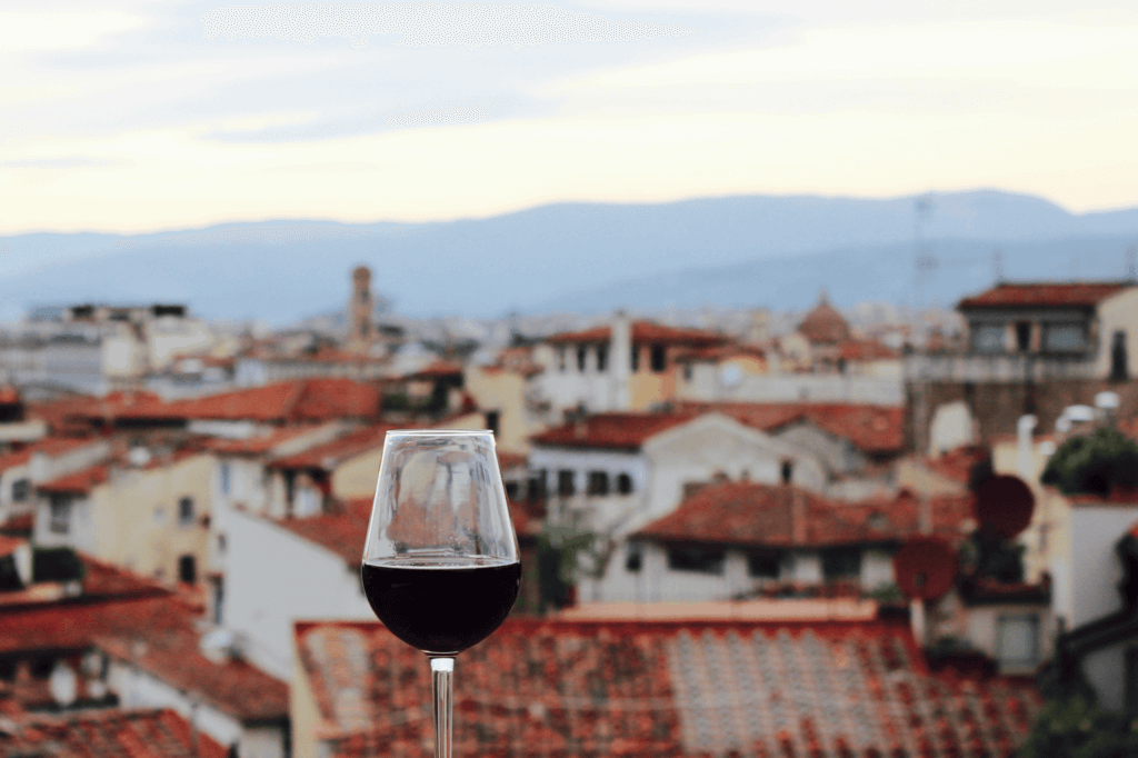 a wine glass overlooking the tops of buildings in Florence Italy