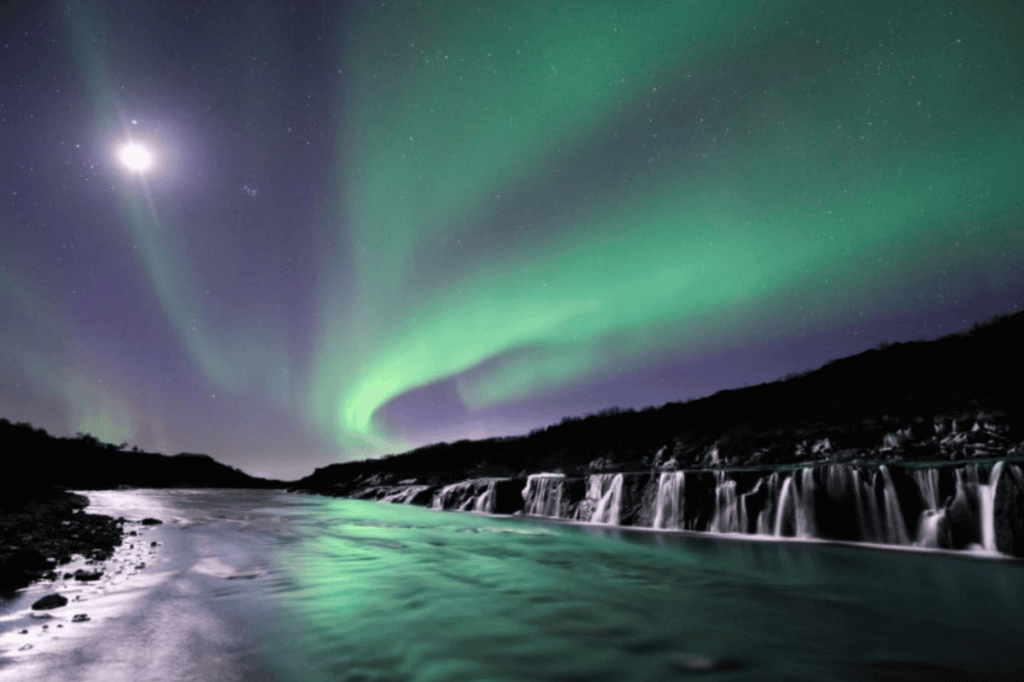 Northern Lights over waterfalls in Iceland