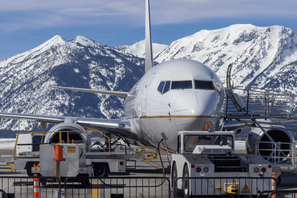 plane with the Grand Tetons in the background at Jackson Hole Airport (JAC)